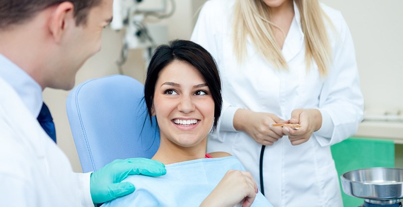 A smiling woman talking with her dentist