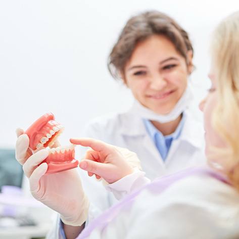 A woman asking her dentist about dentures