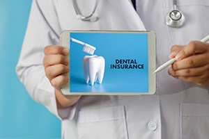 Dentist holding a tablet that reads dental insurance on it