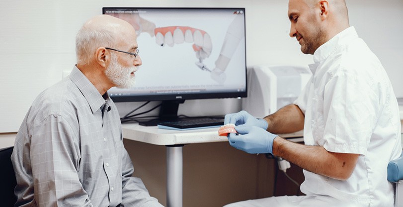 An elderly man consulting his dentist about dentures