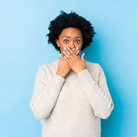 Embarrassed woman covering her mouth