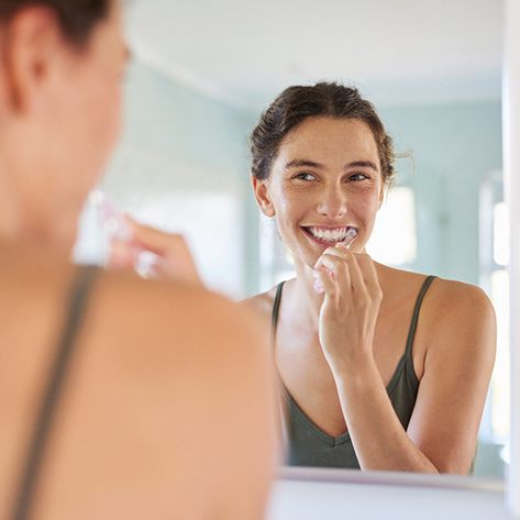 Woman brushing her teeth in bathroom